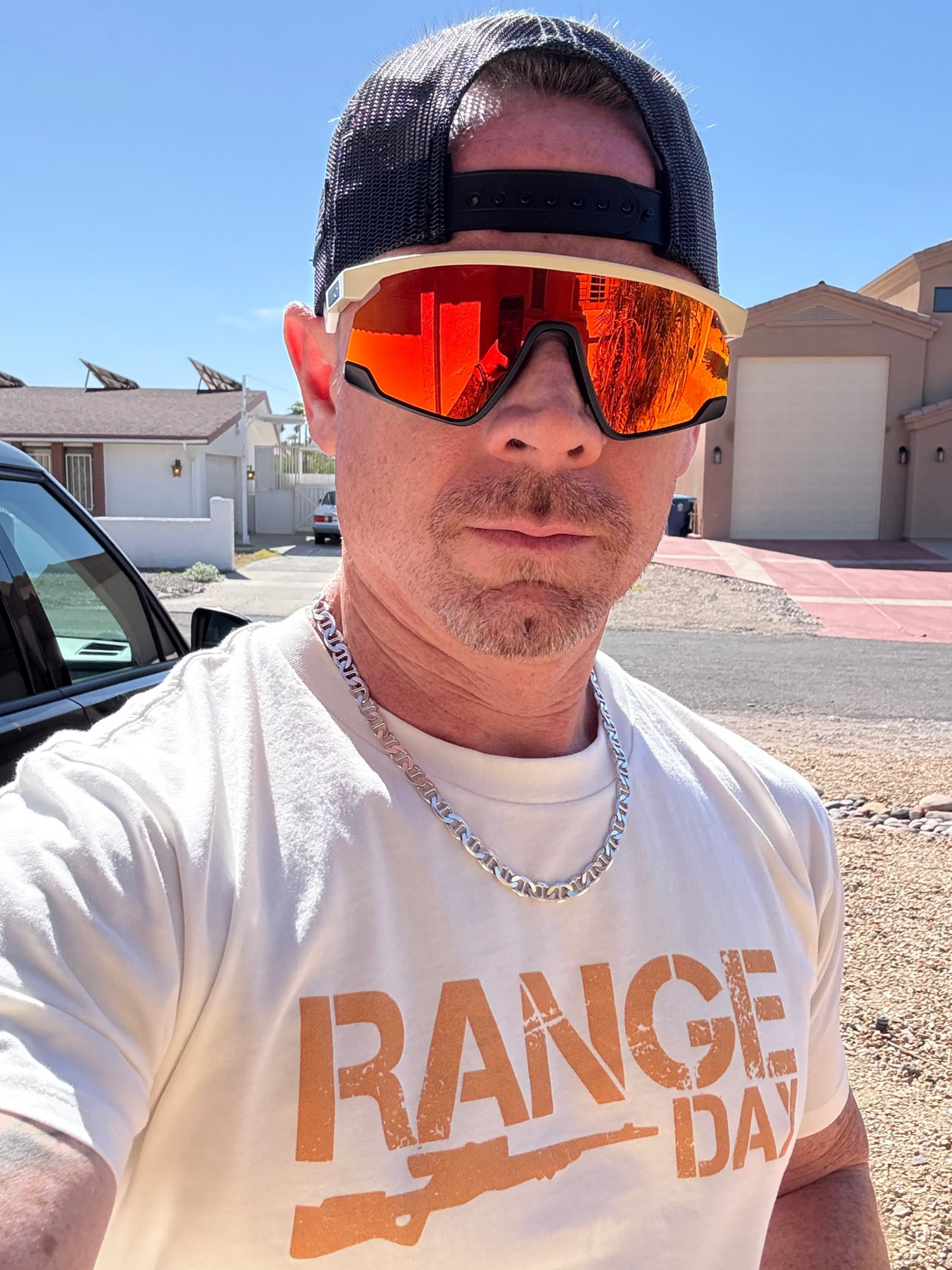 Person wearing reflective sunglasses and a 'Range Day' t-shirt outdoors.